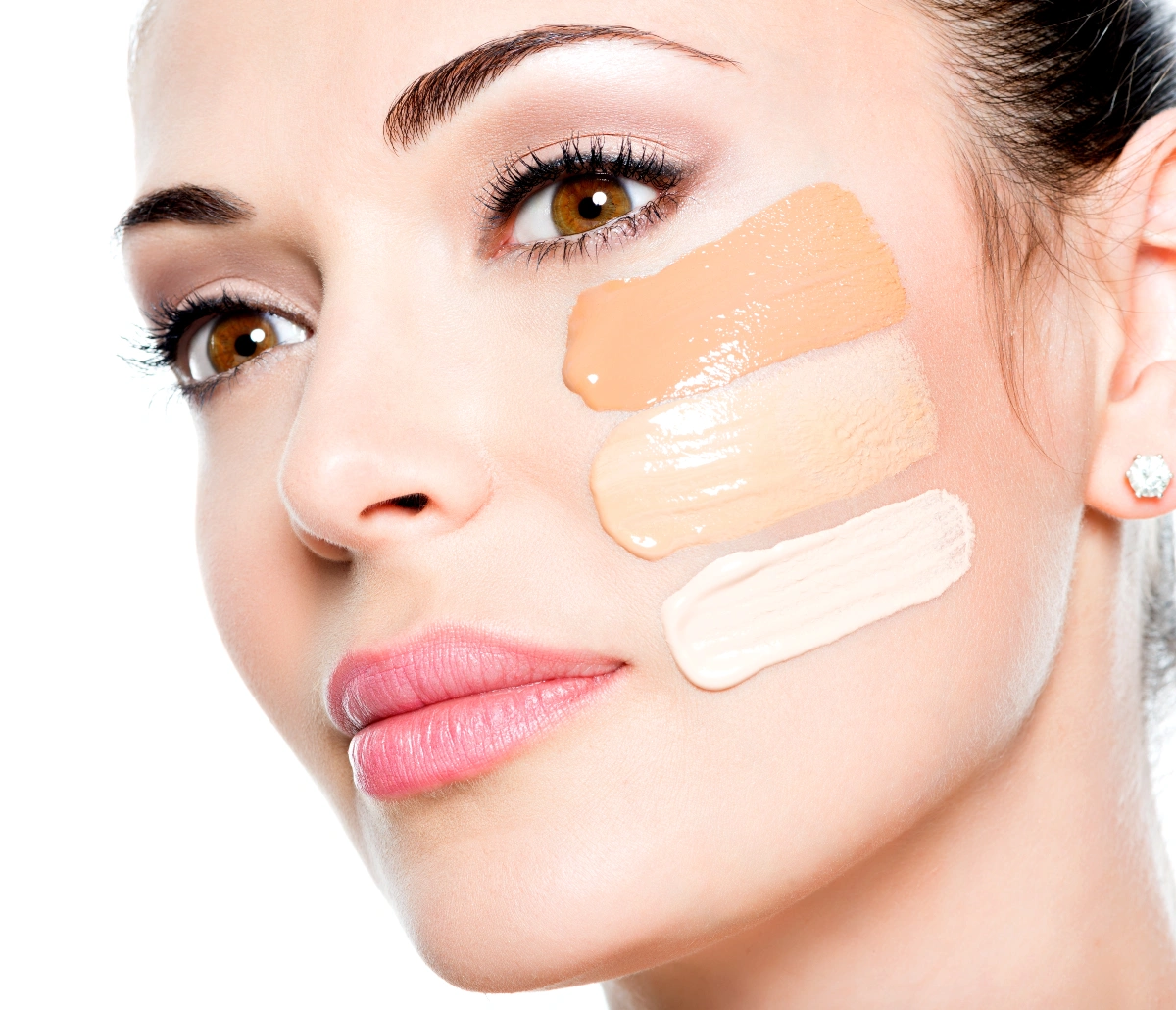 Visage d’une femme avec différents pigments sur la peau prêts à être appliqués